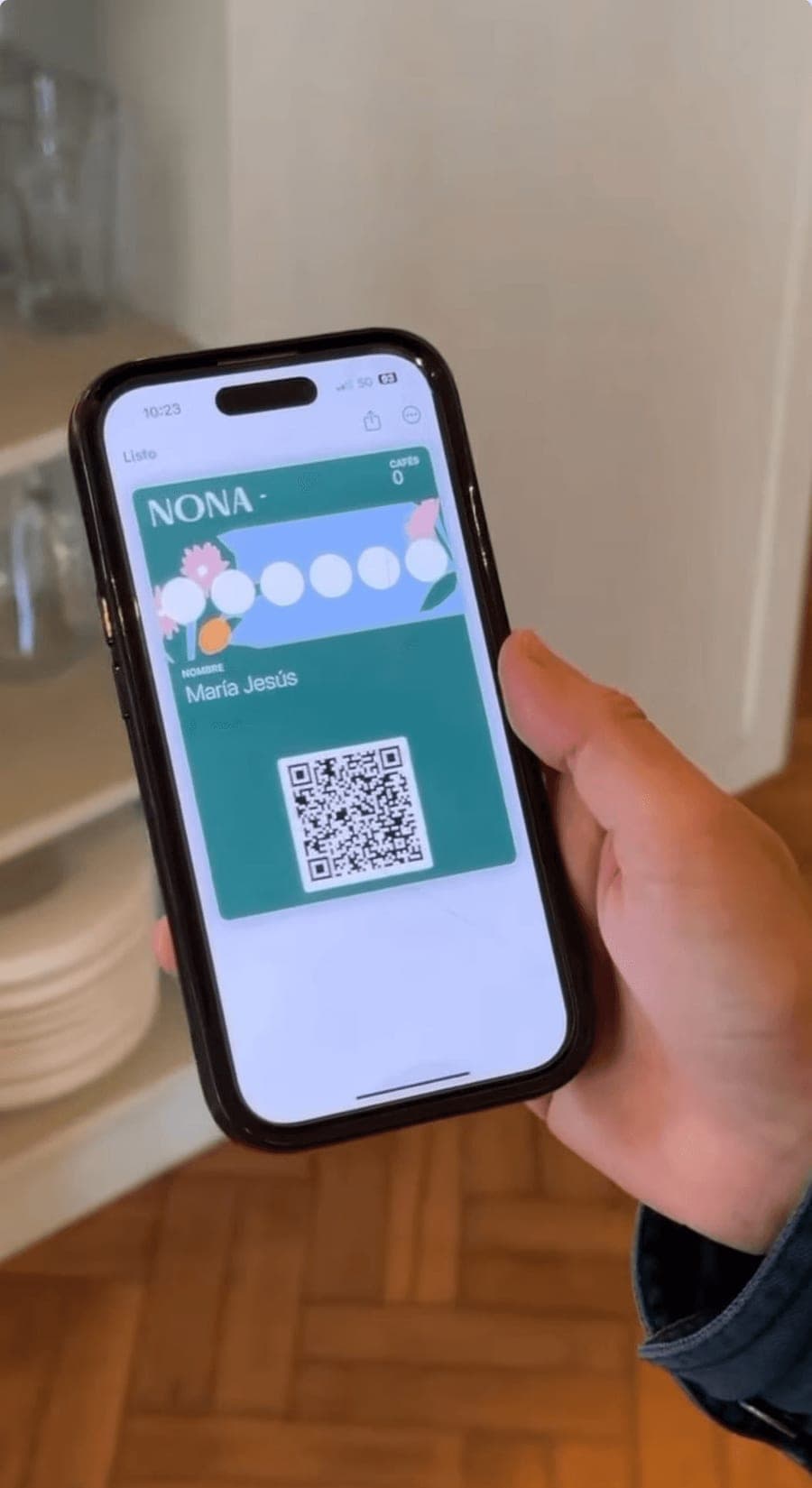 Una clienta abre la tarjeta de sellos de NONA en la wallet de su teléfono.